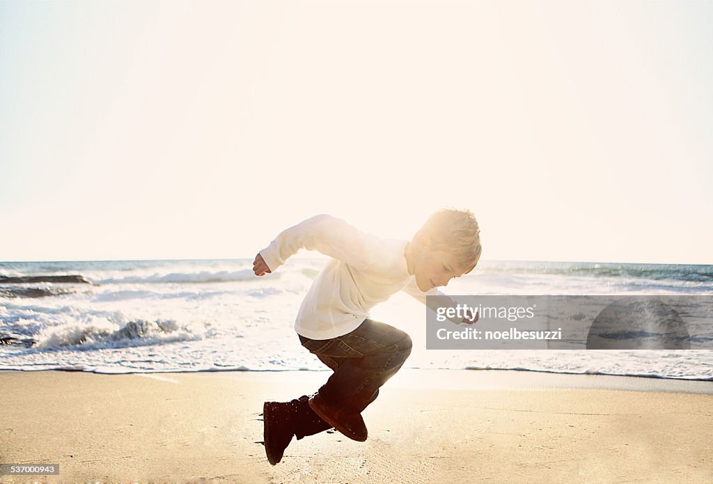 Boy jumping on beach