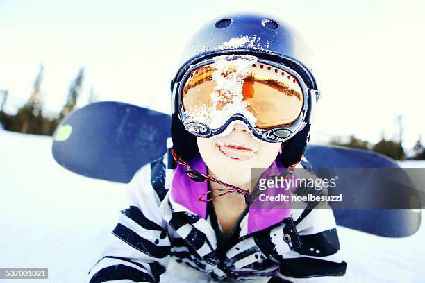 portrait of boy lying in the snow with a snowboard - wipeout sportunfall stock-fotos und bilder