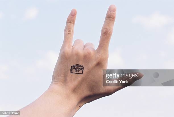 hand with camera tattoo making i love you sign - love you stockfoto's en -beelden