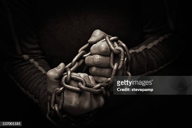 close-up of hands trying to break chains - hostage stock pictures, royalty-free photos & images