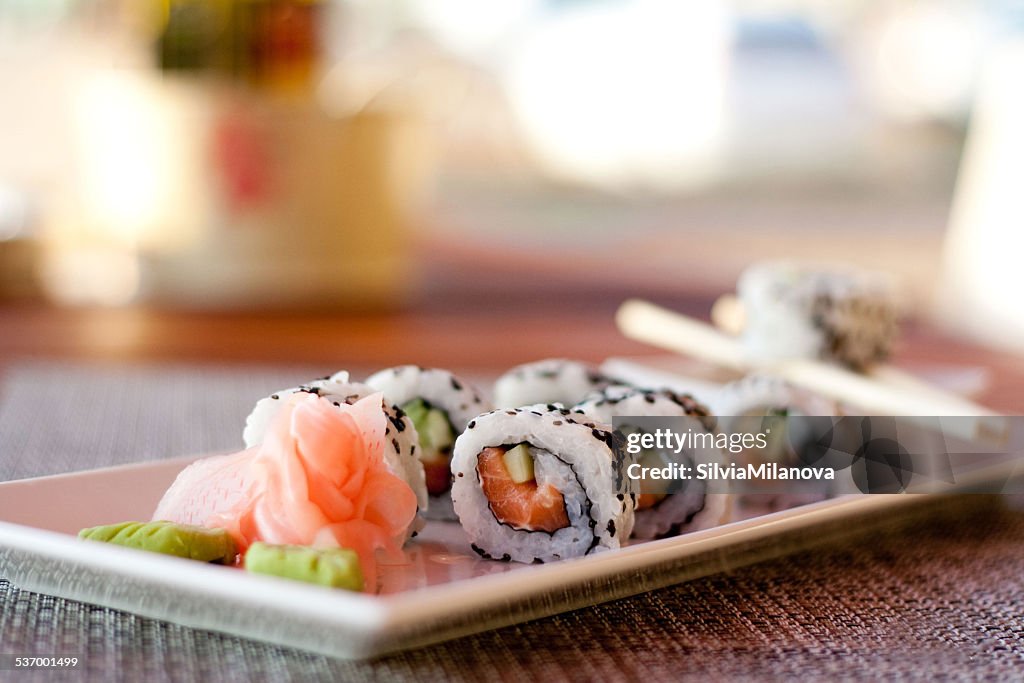 Japanese seafood sushi, roll and chopstick on white plate
