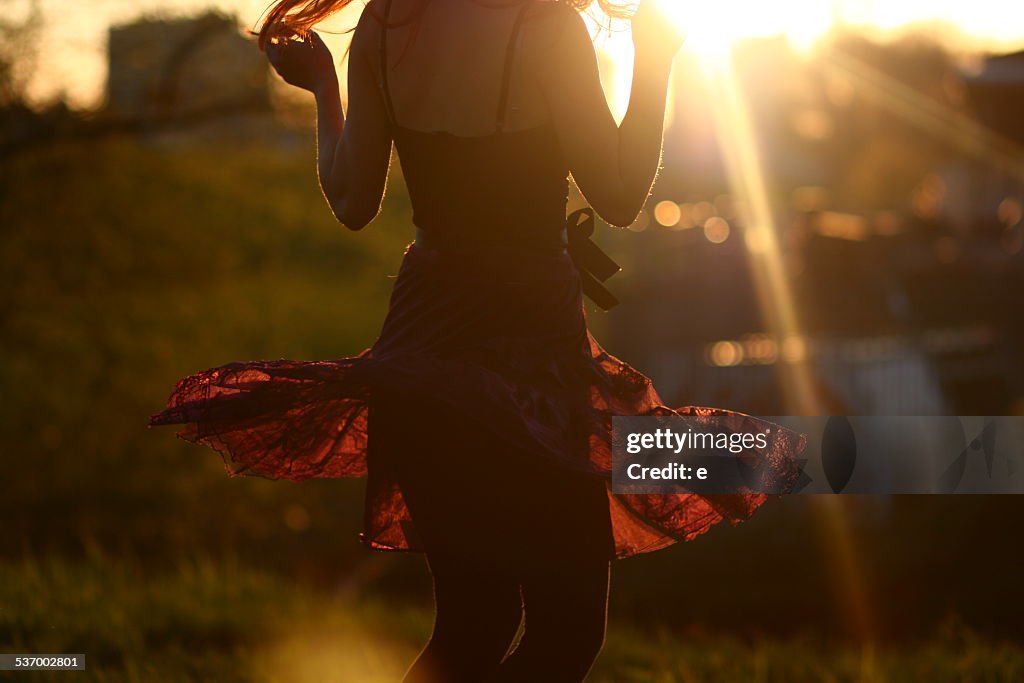 Young woman dancing at sunset