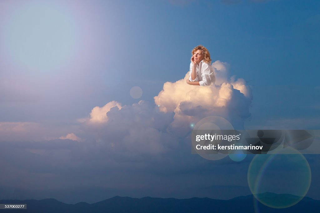 Blonde woman dreaming on cloud