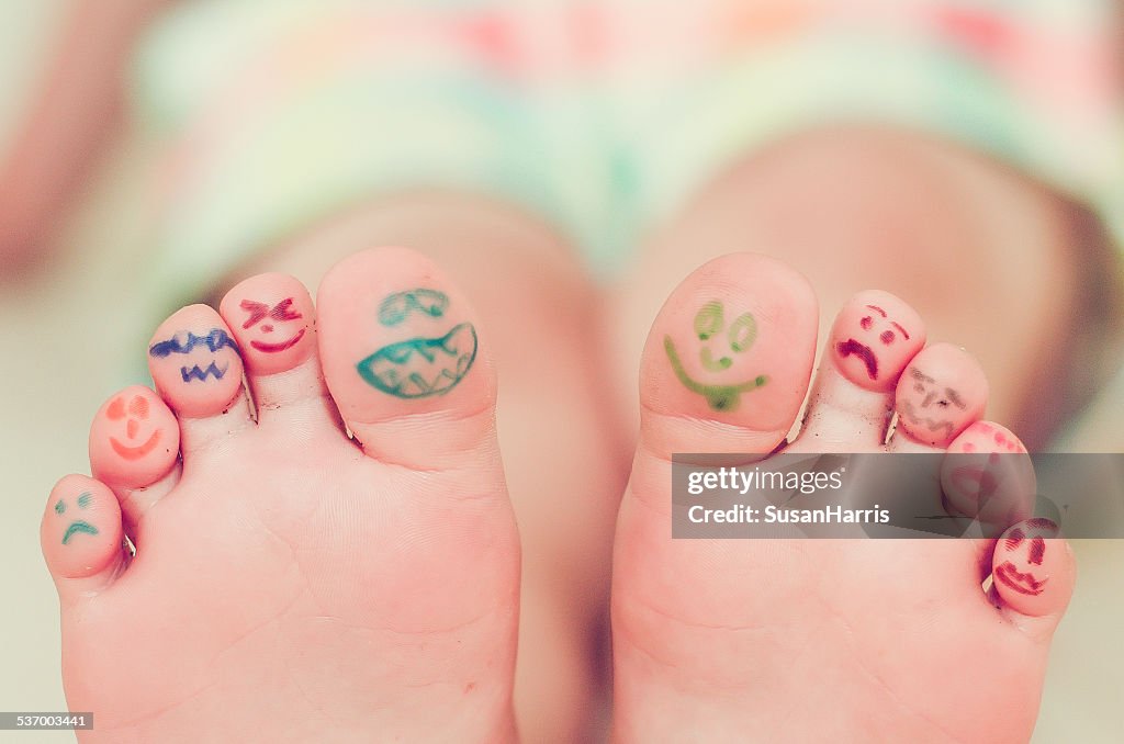 Girls feet with smiley face drawings