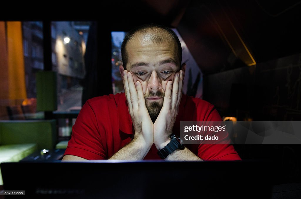 Man sitting and watching at laptop