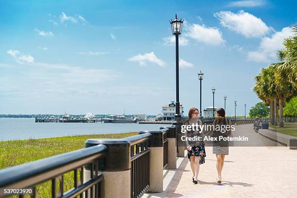 two teenager girls walks in waterfront park, charleston, south carolina - charleston south carolina stock pictures, royalty-free photos & images