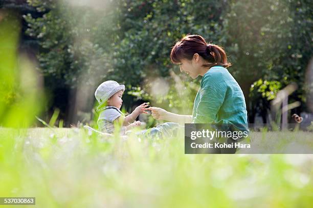 mother and baby playing in the park - 1歳以上2歳未満 ストックフォトと画像