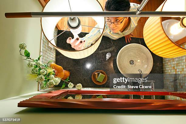 woman changing to led lighting - led lampe stock pictures, royalty-free photos & images