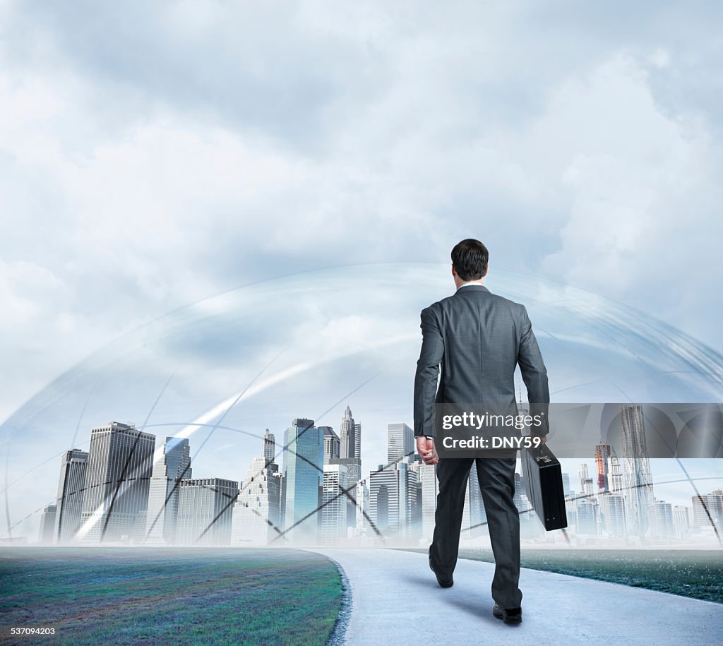 Businessman walking towards protected futuristic city