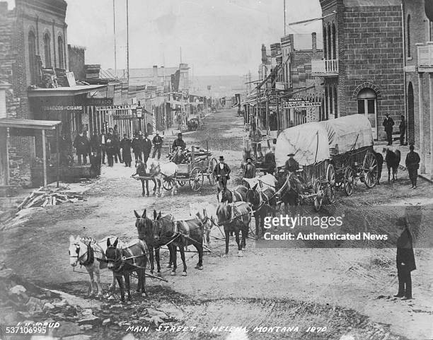 Horse and card being pulled along Main Street, Helena, Montana, 1870.