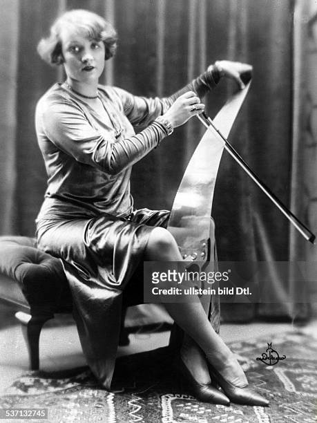 German-born actress Marlene Dietrich playing a musical saw in a scene from 'Cafe Elektric', directed by: Gustav Ucicky, Austria, 1927. Film...