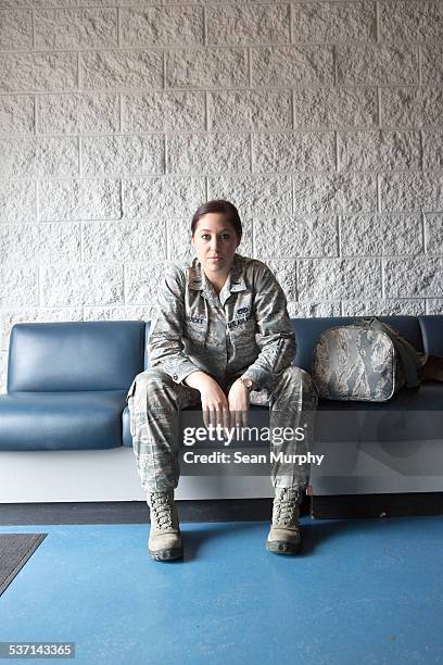 portrait of female soldier sitting on couch - armed forces people stock pictures, royalty-free photos & images