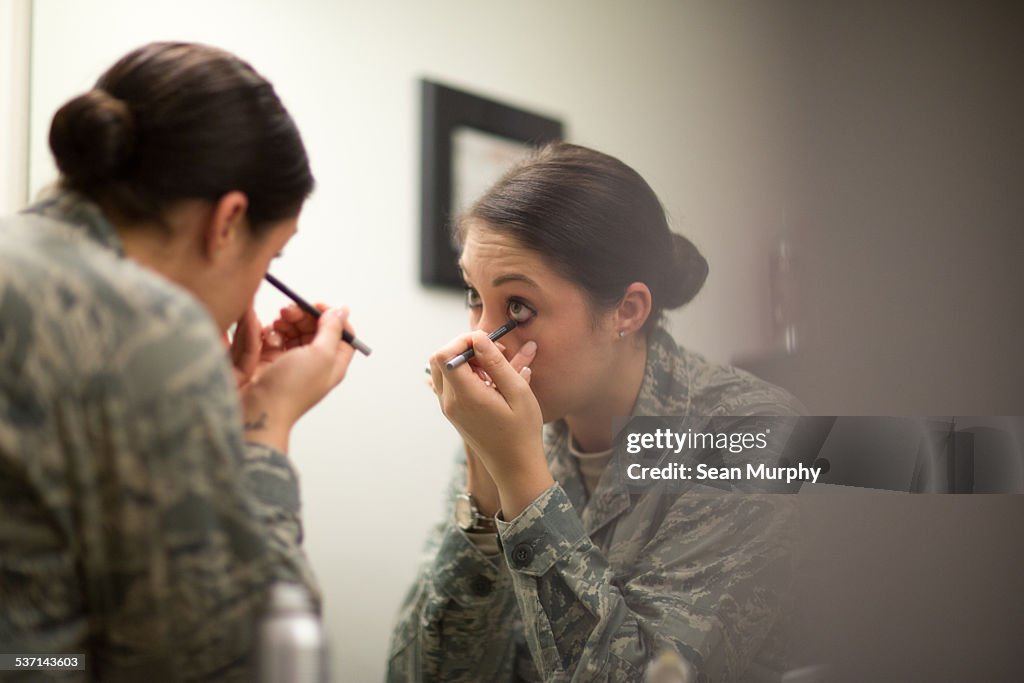 Female Soldier applying Eyeliner in MIrror