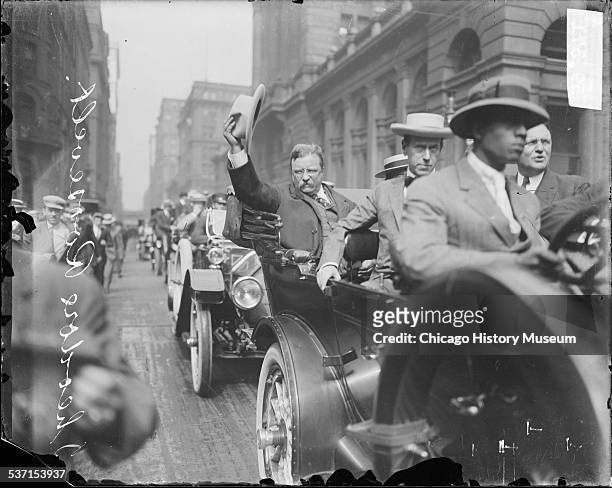 Theodore Roosevelt riding in an automobile, in a procession along West Jackson Boulevard near the Federal Building, Chicago, Illinois, August 6,...
