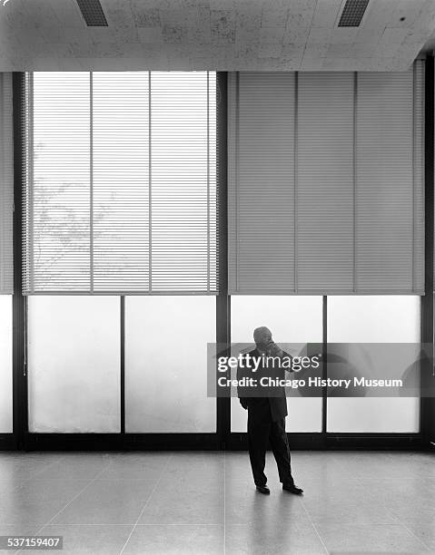 Portrait of Ludwig Mies van der Rohe standing, smoking a cigar in Crown Hall at the Illinois Institute of Technology, Chicago, Illinois, circa 1956.