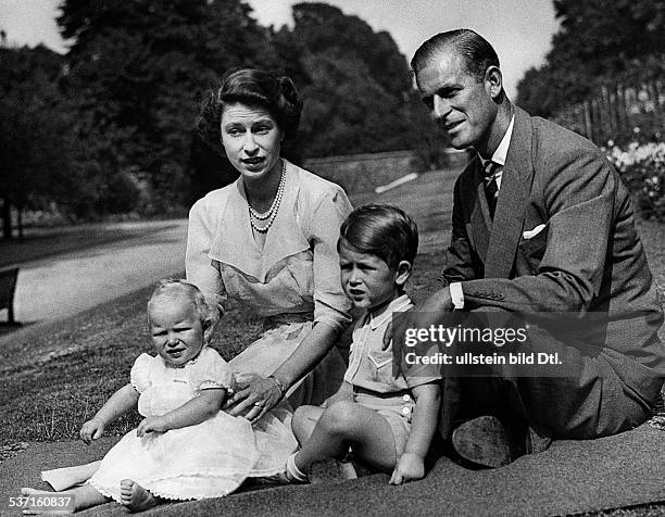 Elisabeth II. , Koenigin von GB seit 1953, - mit ihrem Ehemann Prinz Philip und den Kindern Charles und Anne im Garten von Clarence House, - Juli 1951