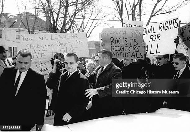 Alabama governor and Democratic presidential nominee hopeful George Wallace walks through a crowd of anti-Wallace demonstrators, protesting the...