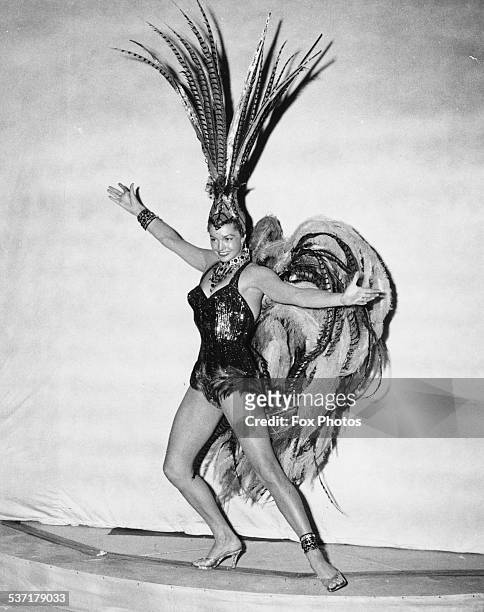 Portrait of swimmer and actress Esther Williams, wearing a feather showgirl costume for the 'Aqua Spectacle of 1956' show, Empire Pool, Wembley,...