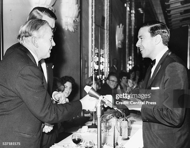 British Prime Minister Harold Wilson presenting an award to racing driver Jim Clark, at the Sportsmen and Sportswomen Annual Dinner, with the Sports...