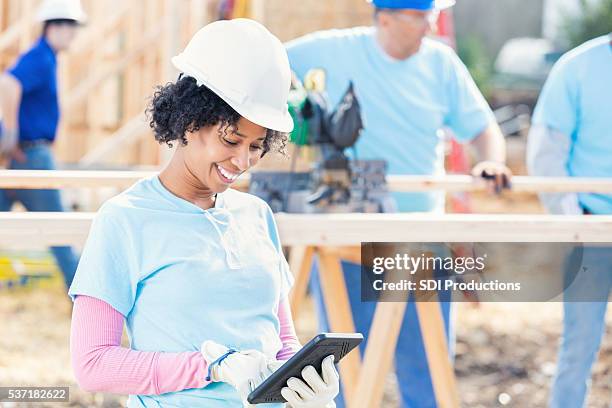 female construction volunteer uses tablet - volunteer building stock pictures, royalty-free photos & images