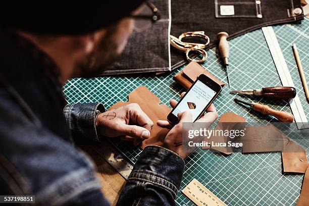 a craftsman checks his mobile website - customized stock-fotos und bilder