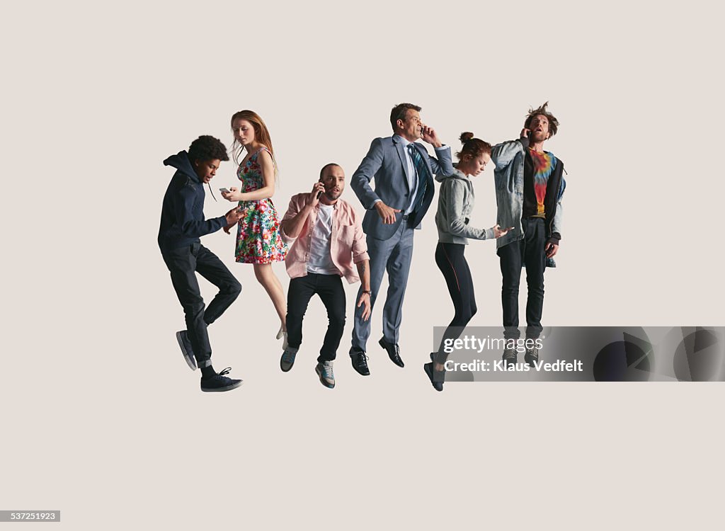 Group of people jumping while holding their phone