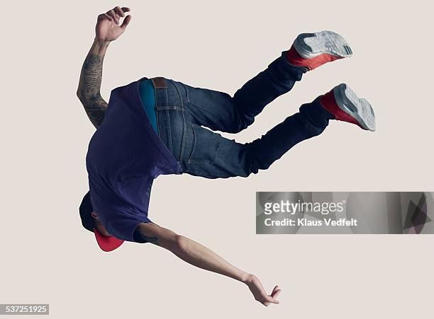 young man hanging in the air, back to camera - jeans back stockfoto's en -beelden