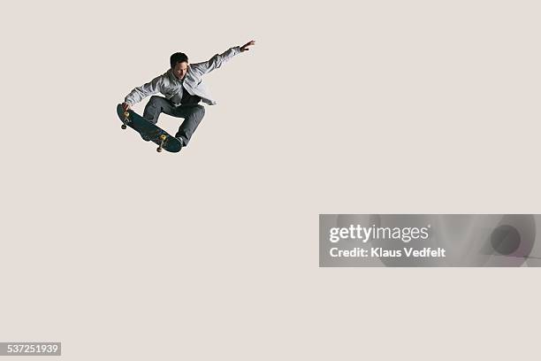 skateboarder doing big air & tail grabbing - stunt person foto e immagini stock