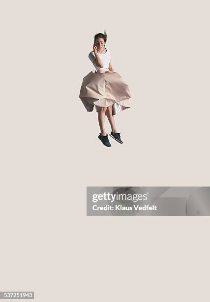 woman holding phone in the & falling down - skirt isolated stock pictures, royalty-free photos & images