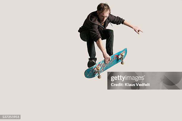 skateboarder grabbing board in the air - skateboard foto e immagini stock