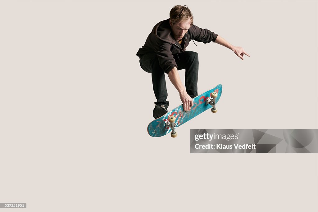 Skateboarder grabbing board in the air