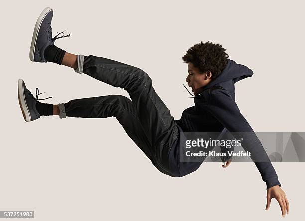 young guy wearing hoodie, falling in the air - cadere foto e immagini stock
