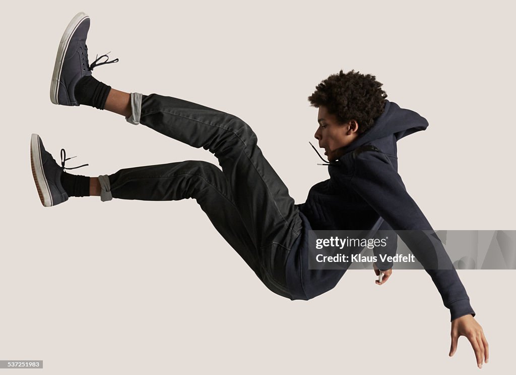 Young guy wearing hoodie, falling in the air