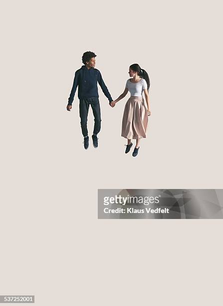 young couple looking at each other, while jumping - people jumping stockfoto's en -beelden