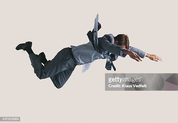 businessman hanging in the air, wearing grey suit - businessman in suit ストックフォトと画像