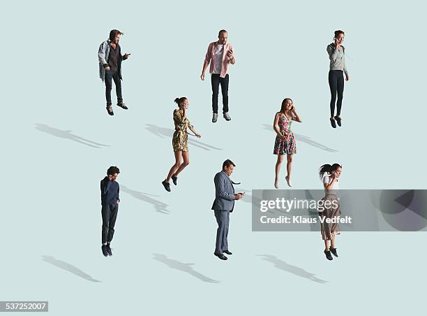 group of people using phone while jumping - floating foto e immagini stock