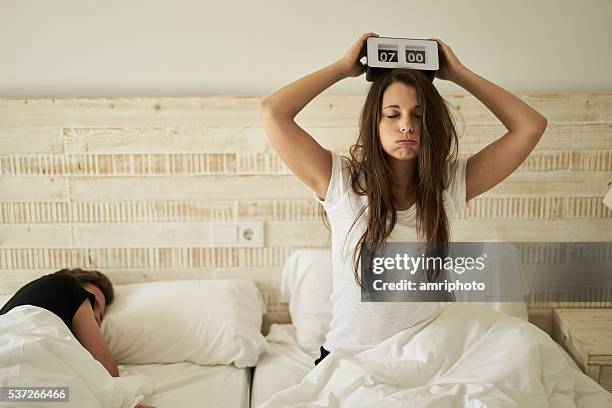 mujer en la cama con el agotamiento - instrumento de tiempo fotografías e imágenes de stock