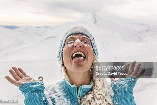 girl catching snow with her tongue - fun snow stockfoto's en -beelden