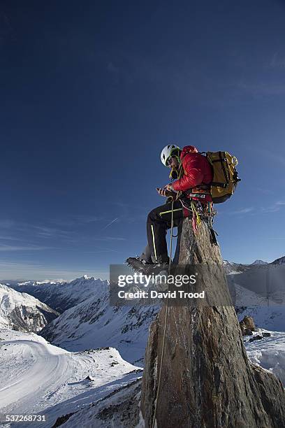 mountain climber smses from a peak - bergsteiger gipfel stock-fotos und bilder