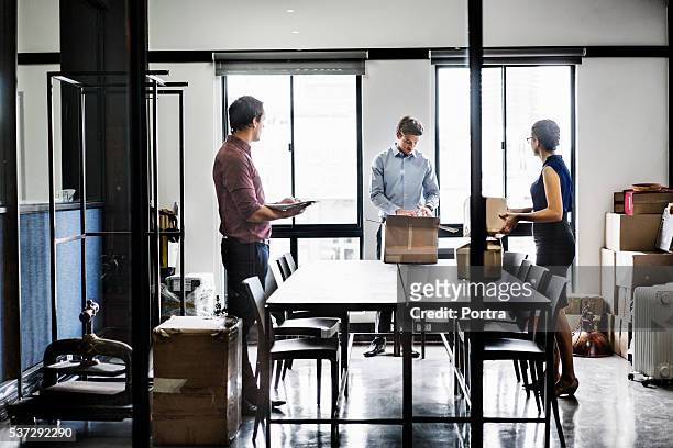 business people with packing boxes in board room - moving office stock pictures, royalty-free photos & images