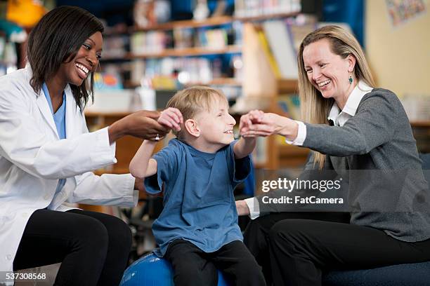 working with a physical therapist - cerebral palsy stock pictures, royalty-free photos & images