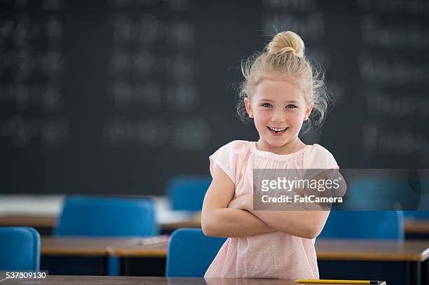 little girl standing in her classroom - elementary school building stock pictures, royalty-free photos & images