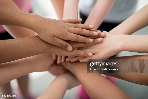 hands together in a huddle - team hands in huddle stock pictures, royalty-free photos & images