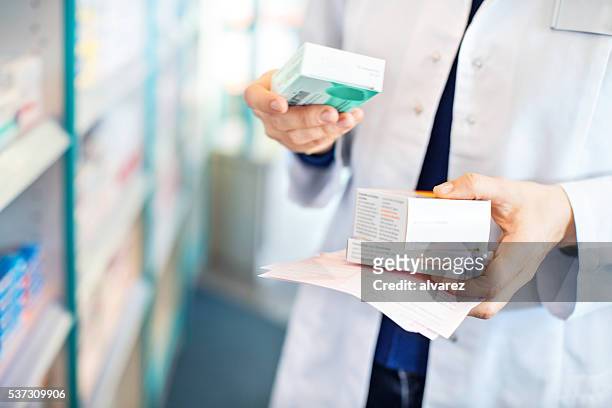 farmacéutico's manos tomando medicamentos de estante - pharmacist fotografías e imágenes de stock