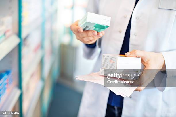 pharmacist's hands taking medicines from shelf - tablet hands stockfoto's en -beelden