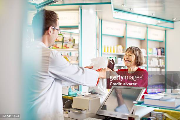 pharmacist’s giving prescription medication to customer - cure berlin 2016 stock pictures, royalty-free photos & images