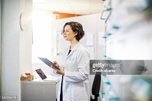 farmacista femmina con un compressa digitale - pharmacist foto e immagini stock