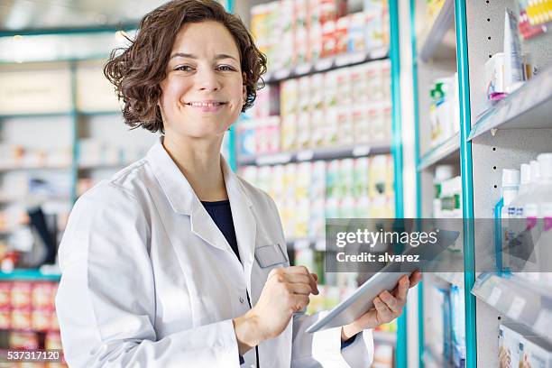 feminino farmacêutico com um tablet digital - female pharmacist with a digital tablet imagens e fotografias de stock