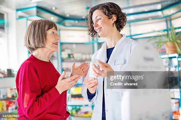 consulenza donna anziana con il farmacista venda il medicinale dosaggio - pharmacist foto e immagini stock