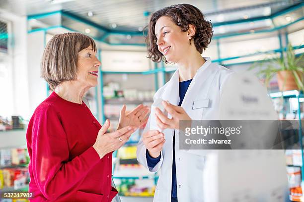 senior woman consulting medicine dosage with the pharmacist - pharmacist explaining stock pictures, royalty-free photos & images